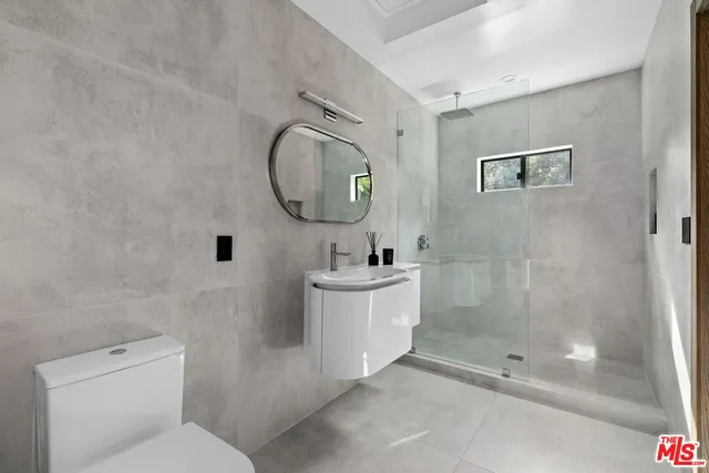 a bathroom with a sink mirror and toilet