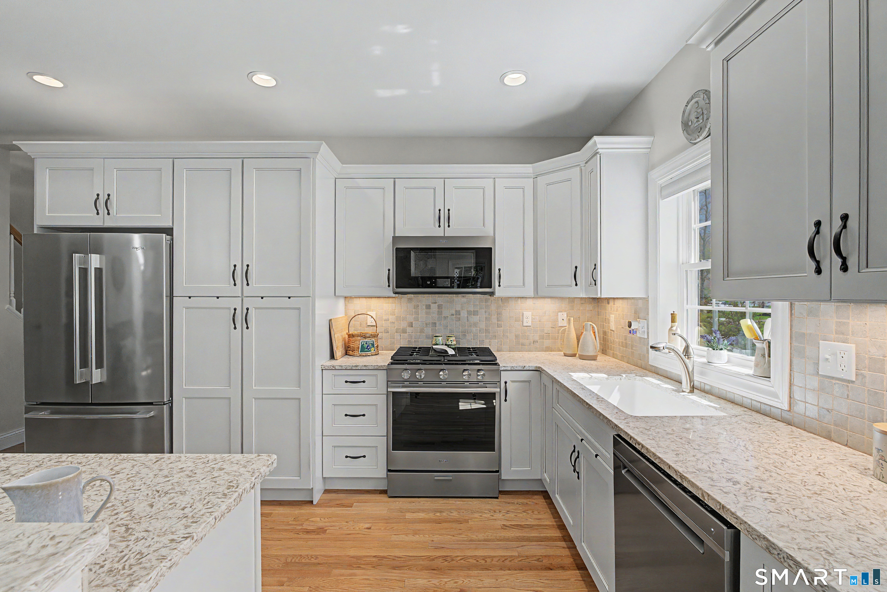 211 Meadowbrook Road, Unit 211 Oxford, CT 06478 - Photo 8 of 38 Kitchen featuring crisp white cabinetry, granite countertops, stainless steel appliances, and a sunlit window over the sink.