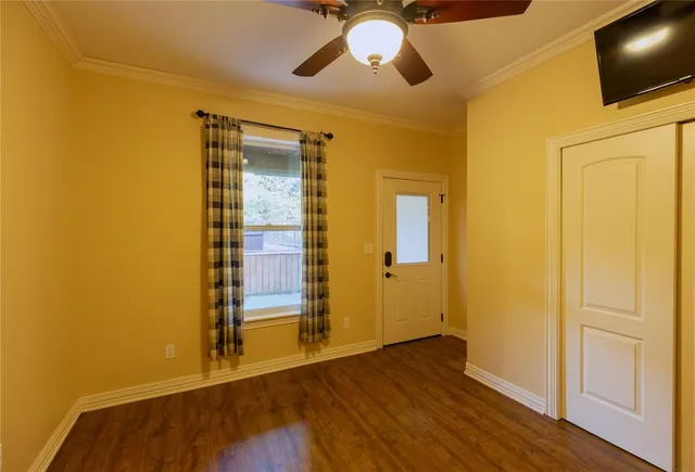 a view of a livingroom with wooden floor and a ceiling fan