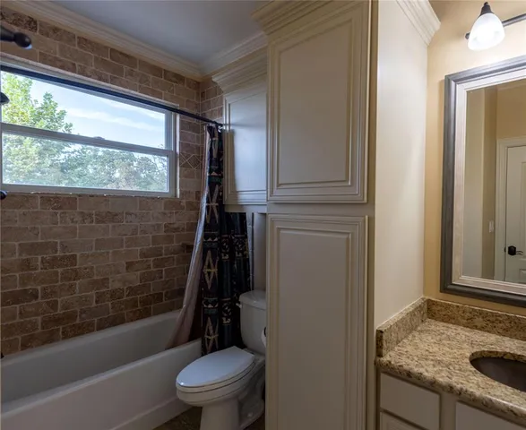 an empty room with a chandelier fan and a window