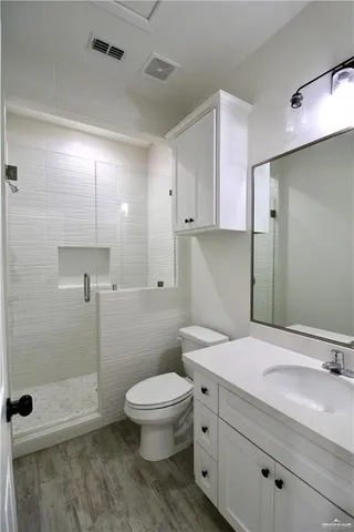 a bathroom with a sink a toilet and shower
