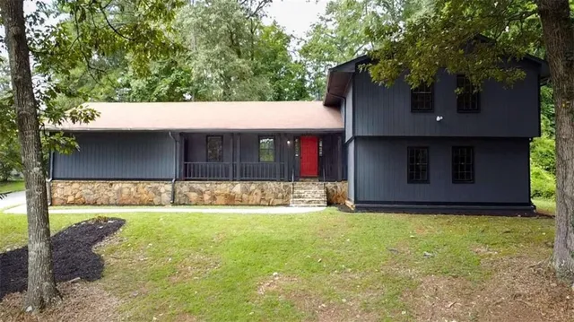 a view of a house with a yard and tree