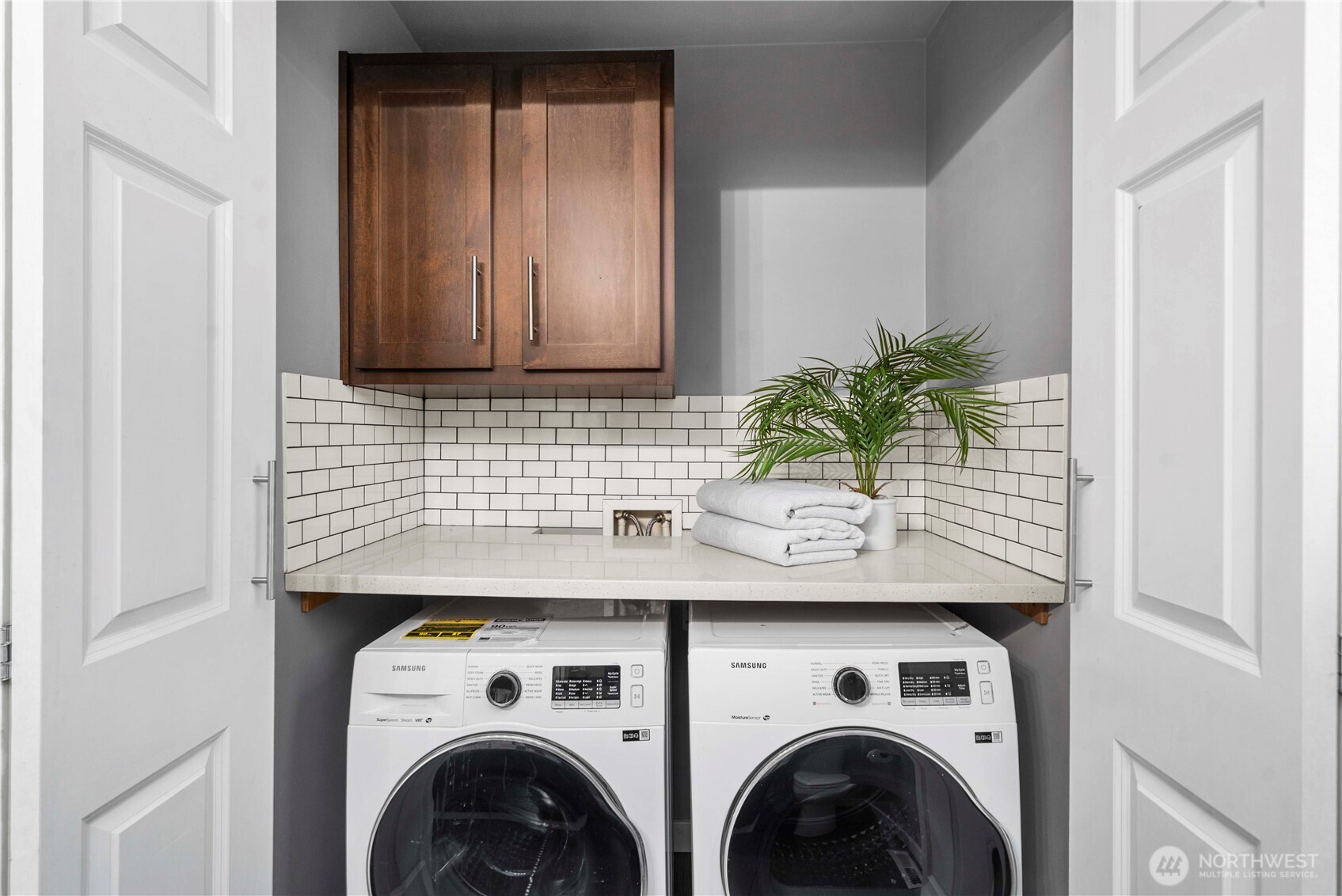 13827 Macadam Road South Tukwila, WA 98168 - Photo 14 of 29 a view of washer and dryer with kitchen in the background