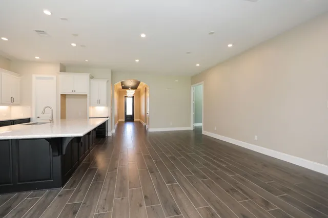a view of wooden floor and a chandelier fan in a room