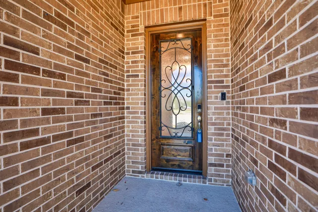 an empty room with wooden floor cabinet and windows