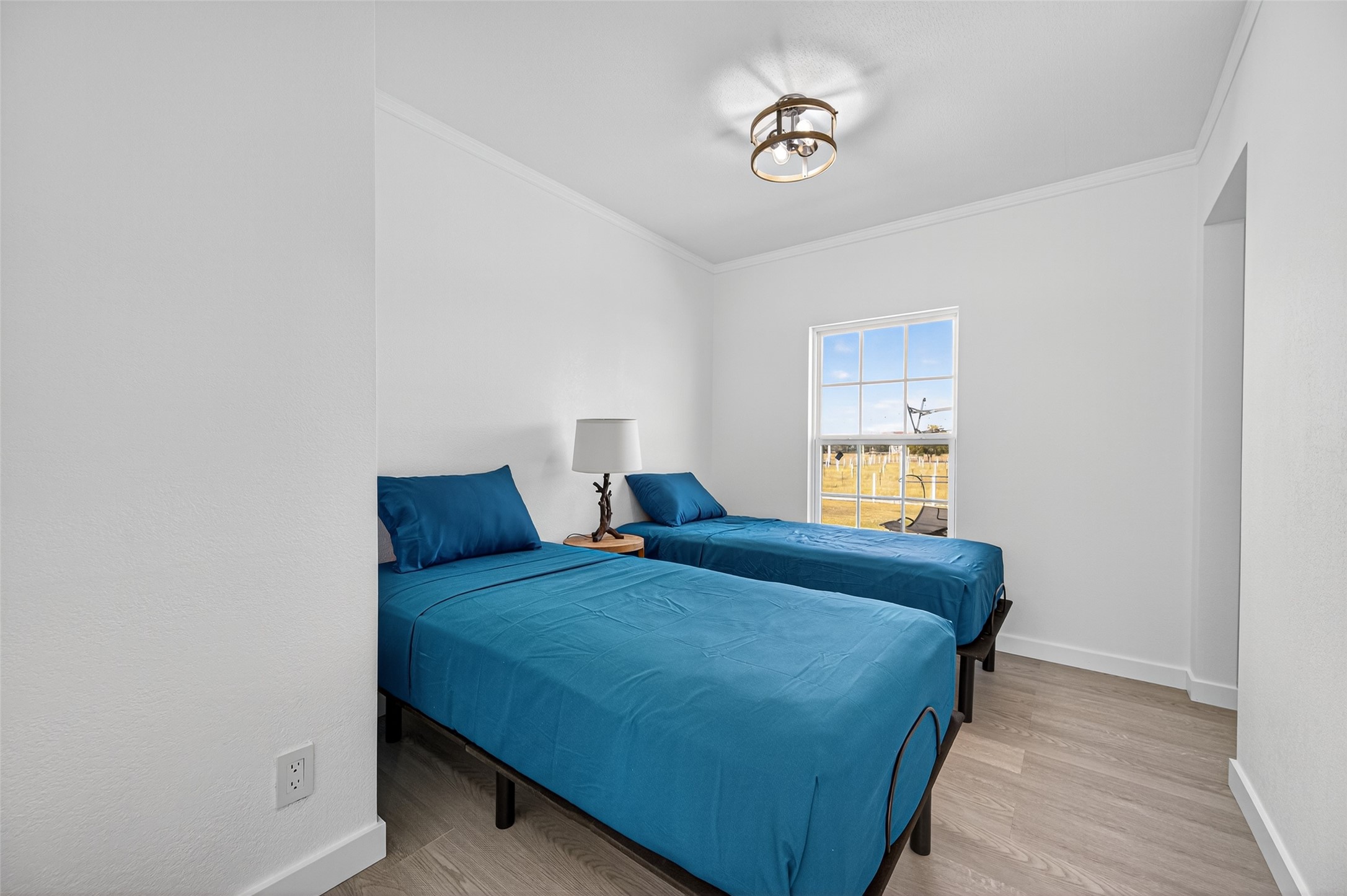 805 Williams Road East Bernard, TX 77435 - Photo 18 of 47 Secondary bedroom featuring neutral finishes, modern lighting, and a window overlooking open acreage—ideal for guests or flexible use.