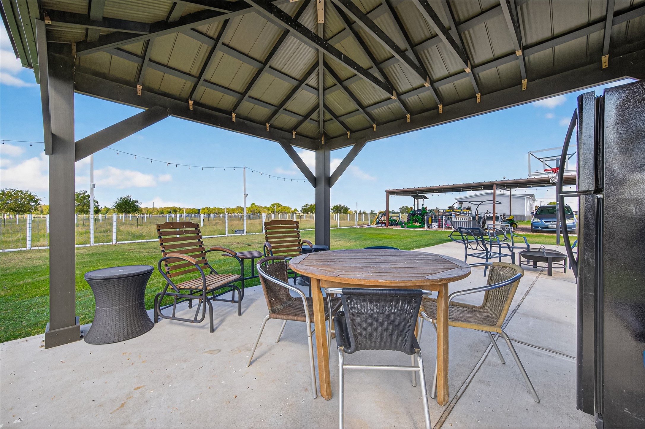 805 Williams Road East Bernard, TX 77435 - Photo 35 of 47 Gazebo-covered patio with seating area, overlooking fenced pasture and open acreage—perfect for outdoor dining and relaxing.