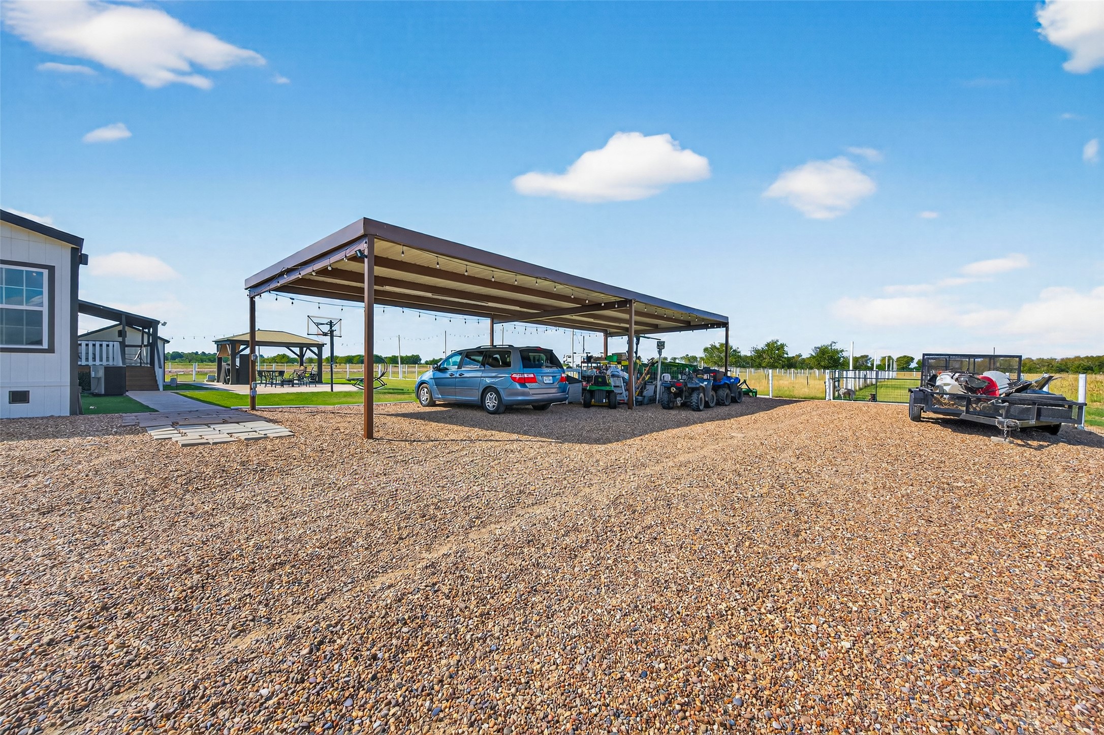 805 Williams Road East Bernard, TX 77435 - Photo 41 of 47 Covered carport with ample space for multiple vehicles, equipment, or trailers, set on gravel with easy access to the home and outdoor amenities.