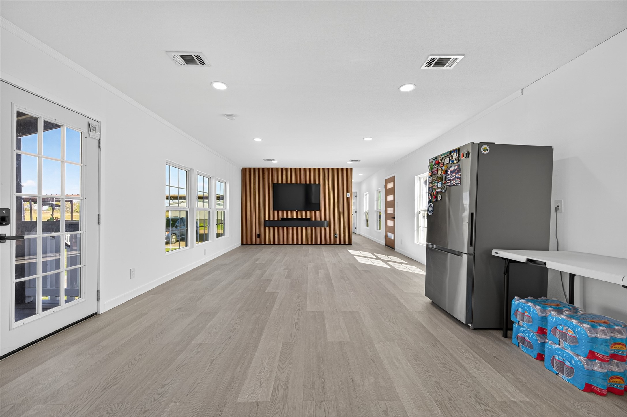 805 Williams Road East Bernard, TX 77435 - Photo 8 of 47 Spacious open living area with abundant natural light, modern finishes, and a feature accent wall—ideal for comfortable everyday living and entertaining.