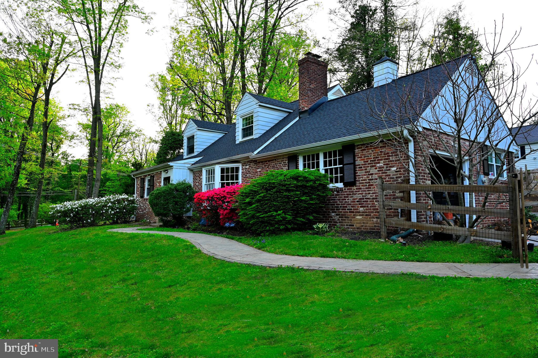 572 Cricket Lane Wayne, PA 19087 - Photo 2 of 37 a front view of a house with a garden and trees