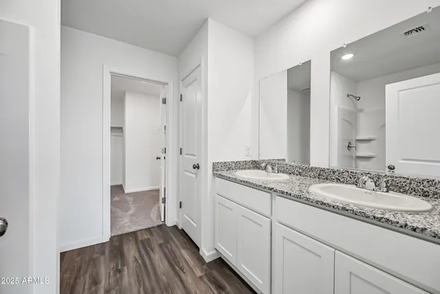 a bathroom with a granite countertop sink a mirror and a shower