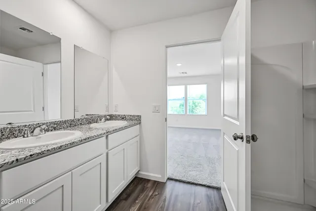 a bathroom with a granite countertop sink toilet and a mirror