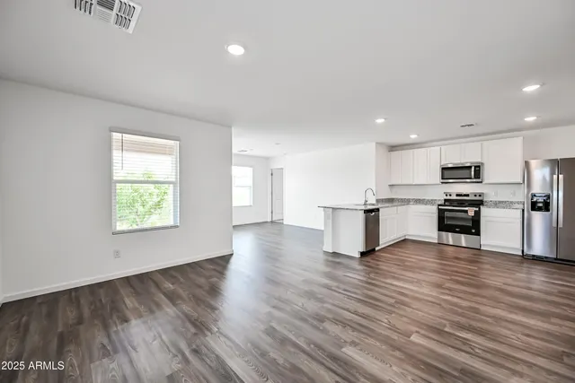 a view of kitchen with wooden floor and electronic appliances