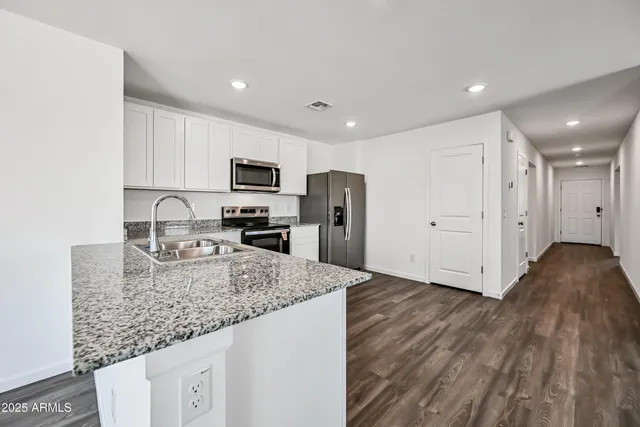 a kitchen with granite countertop a refrigerator and a sink