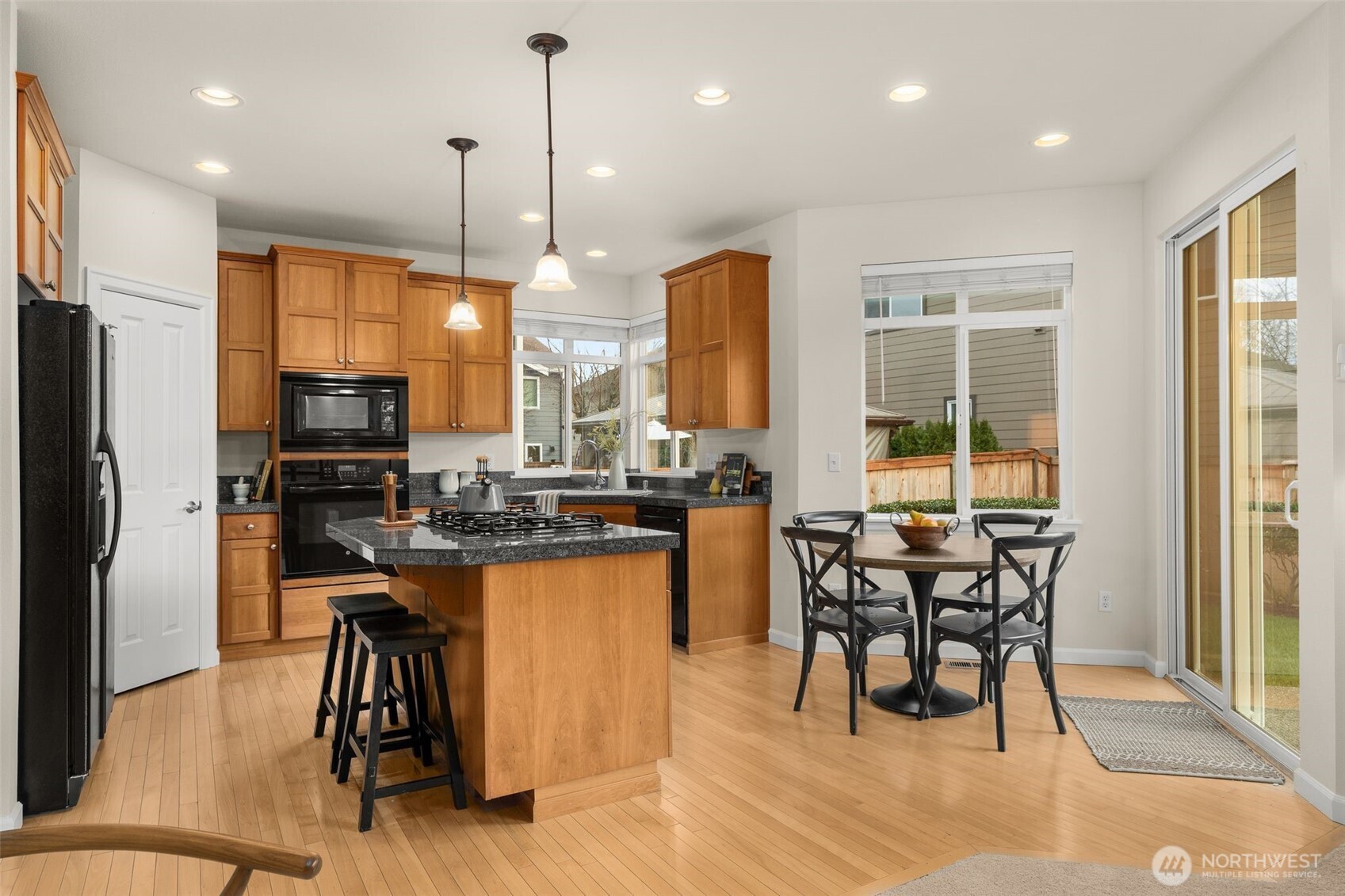 16101 Southeast 251st Street Covington, WA 98042 - Photo 12 of 32 a kitchen with stainless steel appliances granite countertop table chairs stove and refrigerator