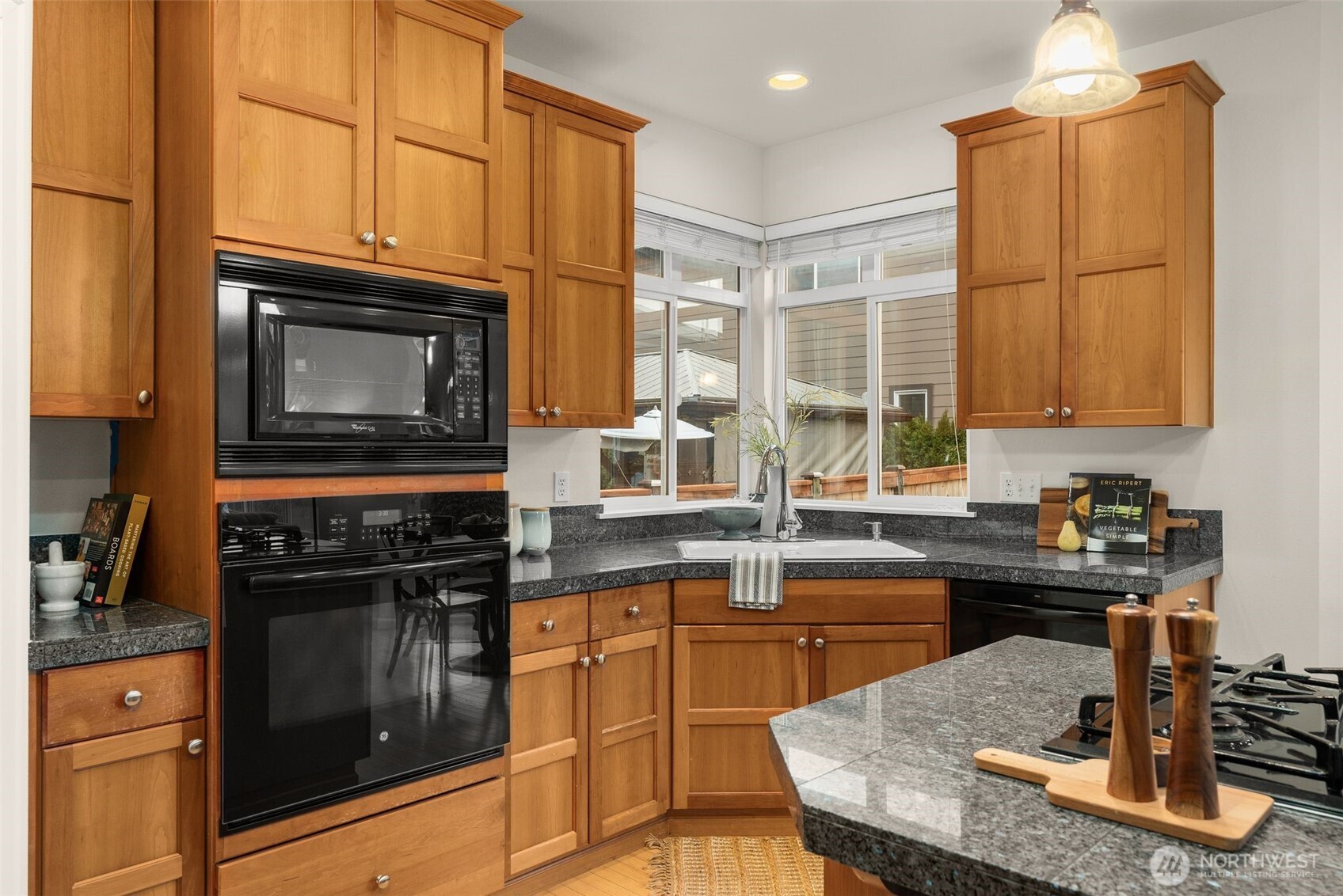 16101 Southeast 251st Street Covington, WA 98042 - Photo 13 of 32 a kitchen with granite countertop a stove a sink and a microwave