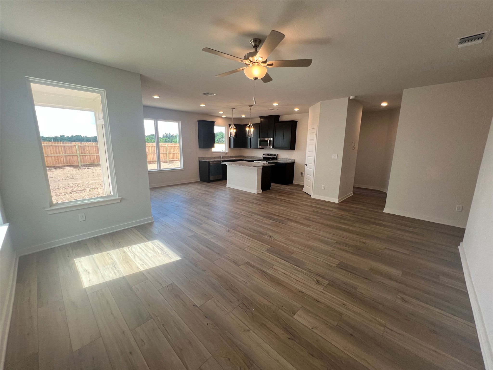 255 Gus Loop Georgetown, TX 78626 - Photo 11 of 24 An open-concept layout unites living and kitchen spaces with seamless wood-look flooring.
