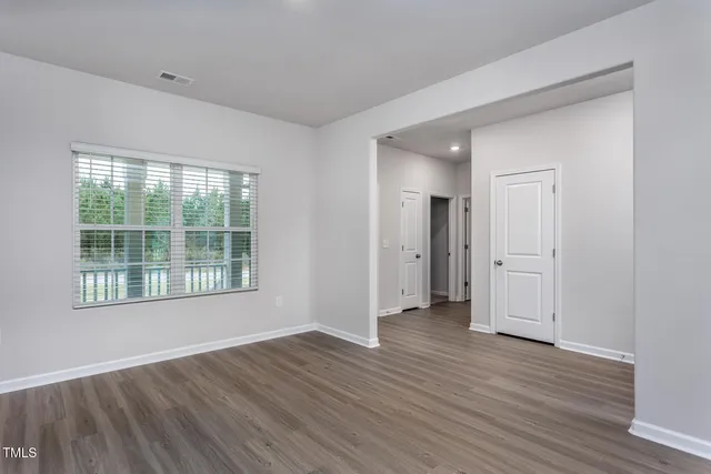 a view of empty room with wooden floor and windows