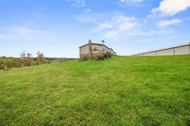 a backyard of a house with lots of green space and mountain view in back