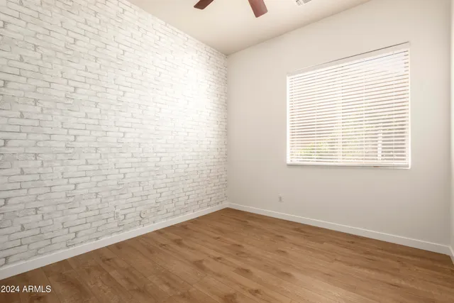 an empty room with a window and a ceiling fan