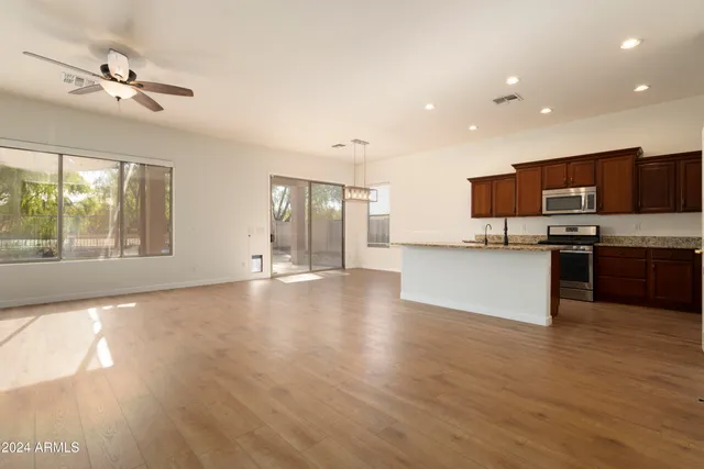 a view of kitchen with microwave a stove and wooden floor