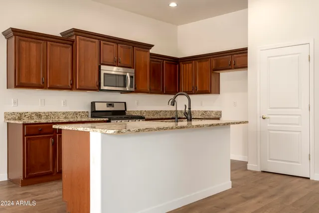 a kitchen with stainless steel appliances granite countertop a stove a sink and a microwave