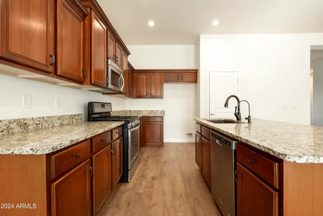 a kitchen with stainless steel appliances granite countertop a sink stove and cabinets
