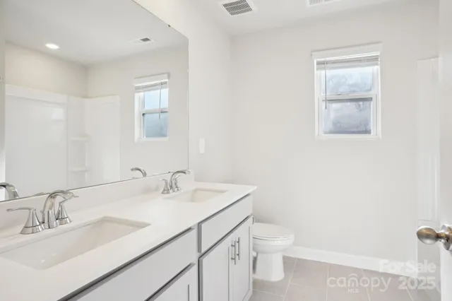 a bathroom with a sink a toilet and a mirror
