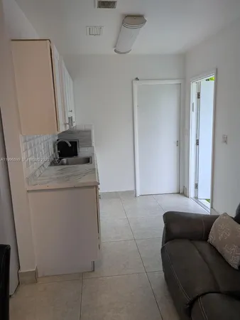 a view of a dining room with furniture and a refrigerator