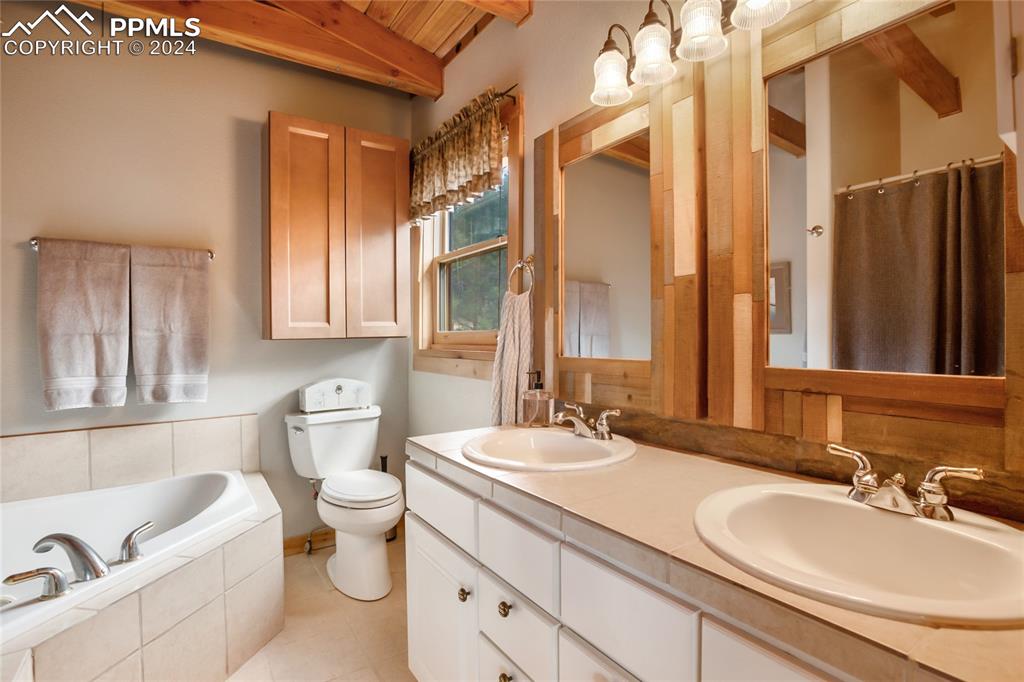143 Wahsatch Road Florissant, CO 80816 - Photo 32 of 50 a bathroom with a granite countertop sink and a large mirror