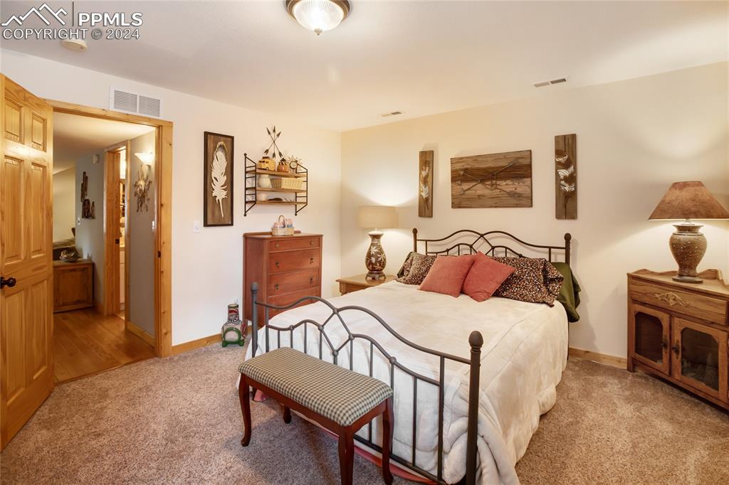 143 Wahsatch Road Florissant, CO 80816 - Photo 45 of 50 a bedroom with a bed and wooden floor