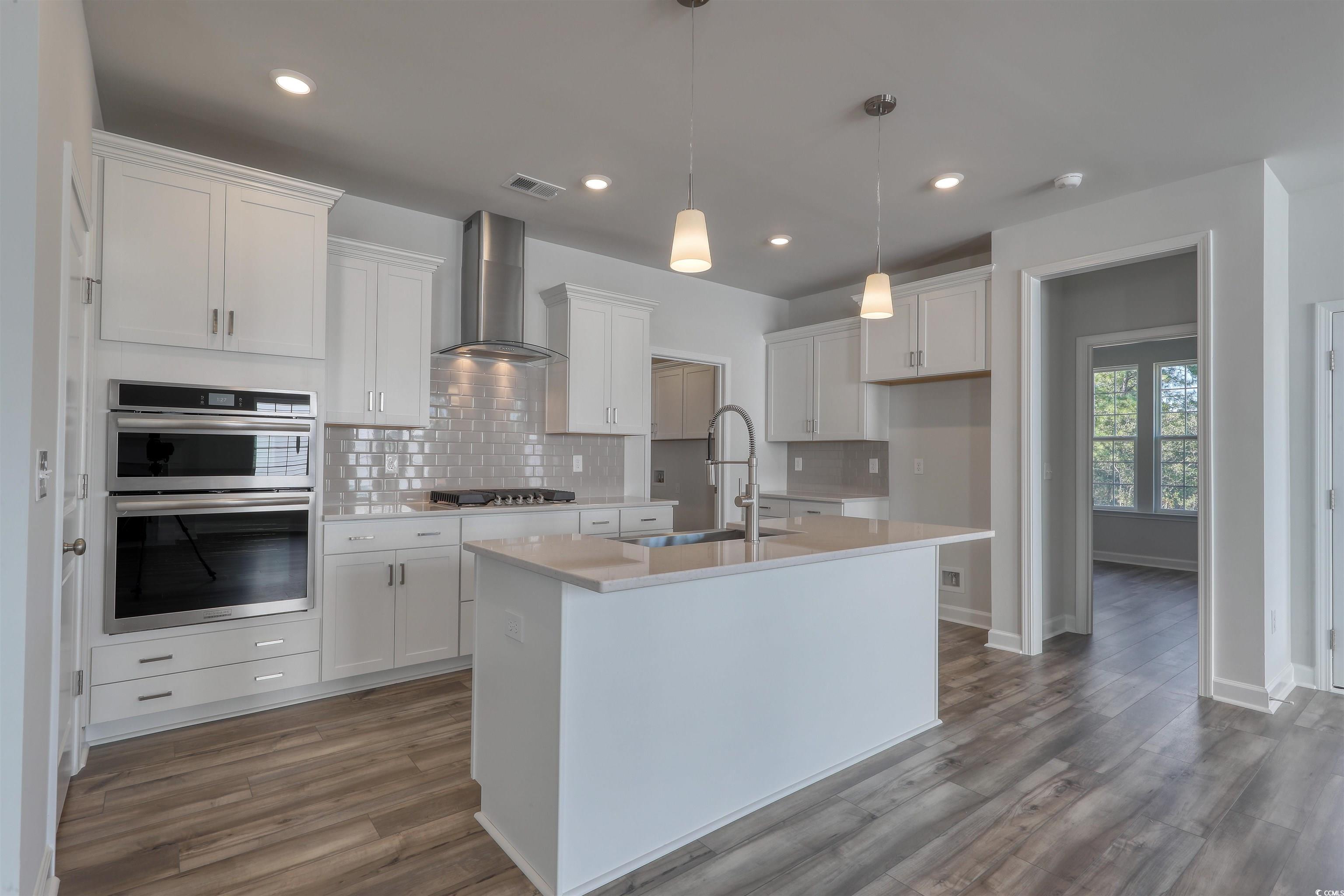 4024 Bucolic Loop Myrtle Beach, SC 29588 - Photo 8 of 29 Kitchen featuring white cabinetry, sink, wall chim