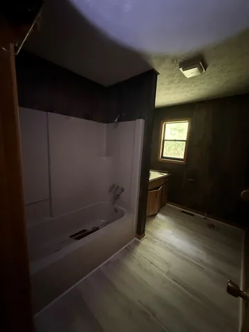 a view of an empty room with a fireplace and a window