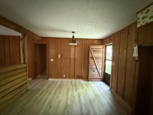 an empty room with wooden floor and a window