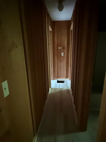 a view of a hallway with a wooden door