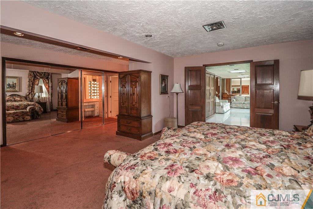 45 Sherwood Road Colonia, NJ 07067 - Photo 15 of 25 a spacious bedroom with a bed and a large mirror