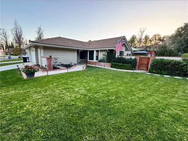 a view of a house with a yard and sitting area