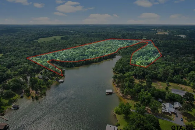 an aerial view of a house with a yard and lake view