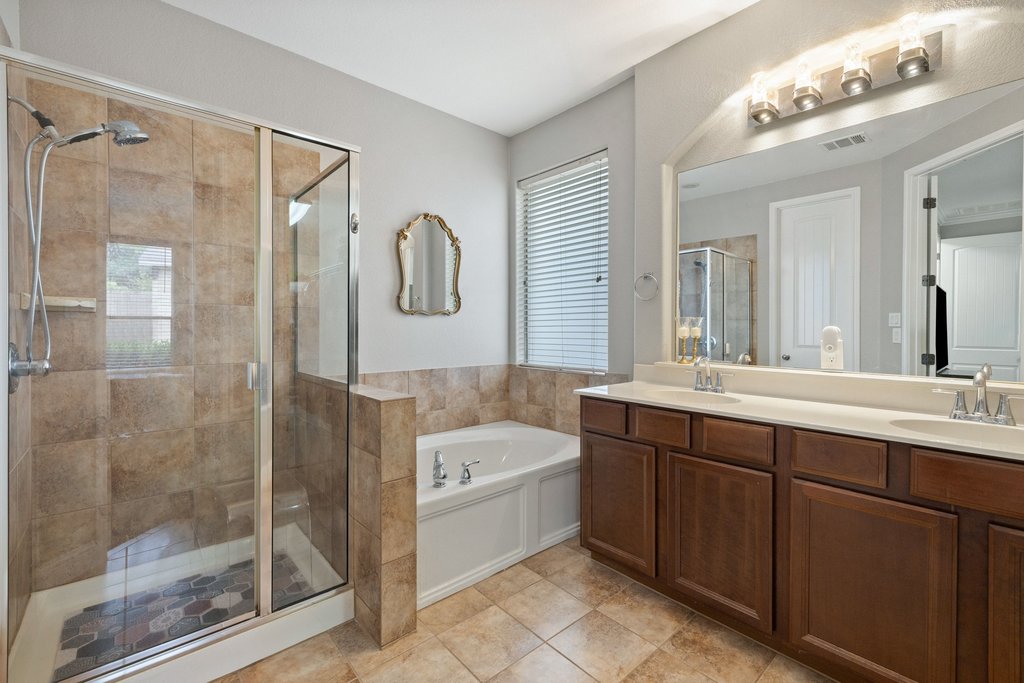 10800 Desert Willow Loop Austin, TX 78748 - Photo 18 of 36 a bathroom with a tub sink shower and mirror