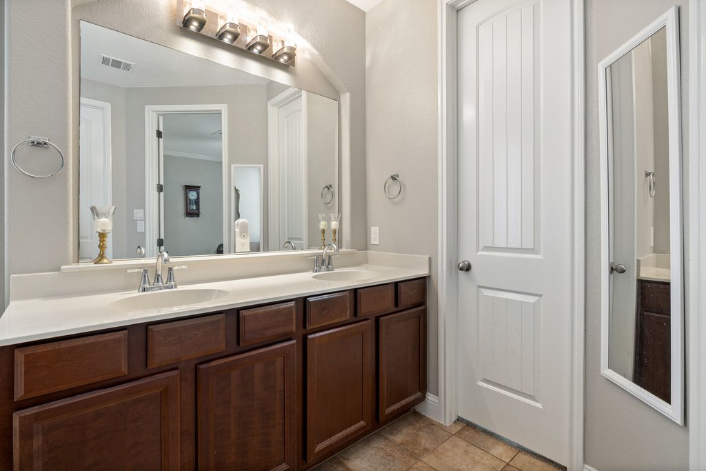 10800 Desert Willow Loop Austin, TX 78748 - Photo 20 of 36 a bathroom with a double vanity sink and a mirror