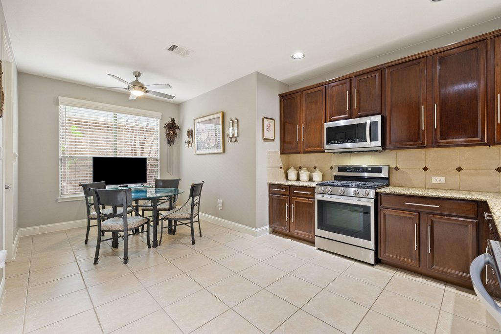 10800 Desert Willow Loop Austin, TX 78748 - Photo 7 of 36 a kitchen with granite countertop cabinets stainless steel appliances and dining table