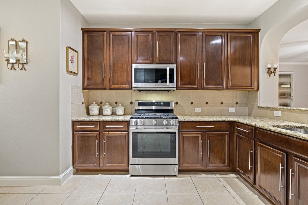 10800 Desert Willow Loop Austin, TX 78748 - Photo 8 of 36 a kitchen with granite countertop a stove top oven microwave and cabinets