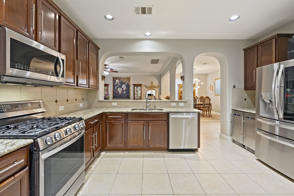10800 Desert Willow Loop Austin, TX 78748 - Photo 9 of 36 a kitchen with stainless steel appliances granite countertop a stove a sink and a microwave