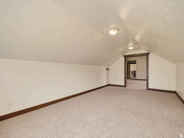 1279 West 1500th Street North Mapleton, UT 84664 - Photo 51 of 83 Carpeted attic space featuring sloped ceilings, recessed lighting, and a framed doorway
