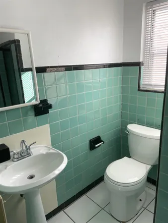 a bathroom with a sink a toilet and a mirror