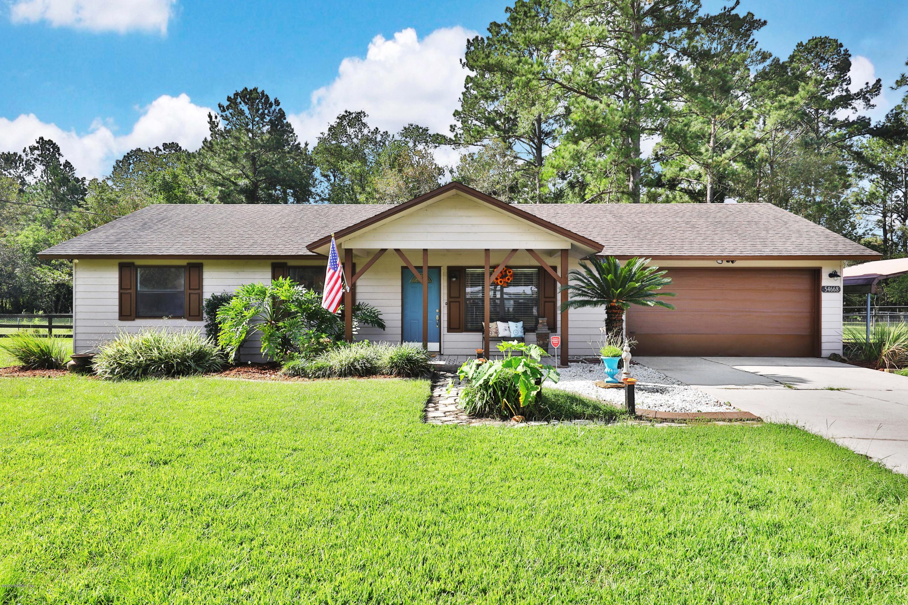 54668 Dornbush Road Callahan, FL 32011 - Photo 1 of 22 a front view of a house with a garden