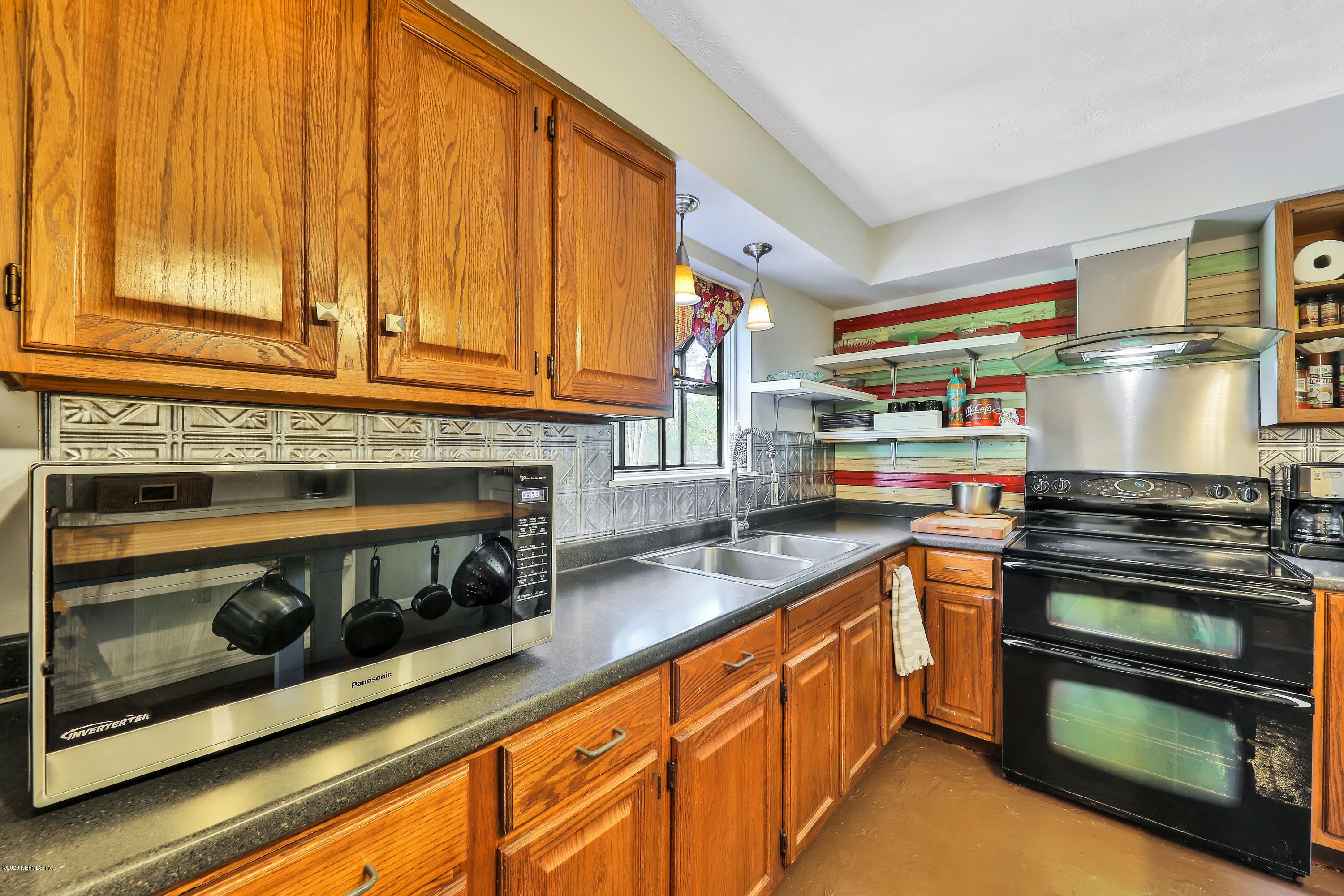 54668 Dornbush Road Callahan, FL 32011 - Photo 9 of 22 a kitchen with stainless steel appliances wooden cabinets and a stove top oven
