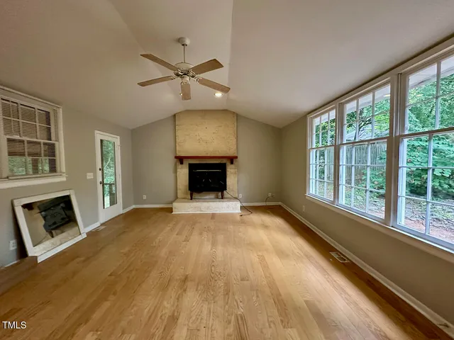 a view of an empty room with a fireplace and a window