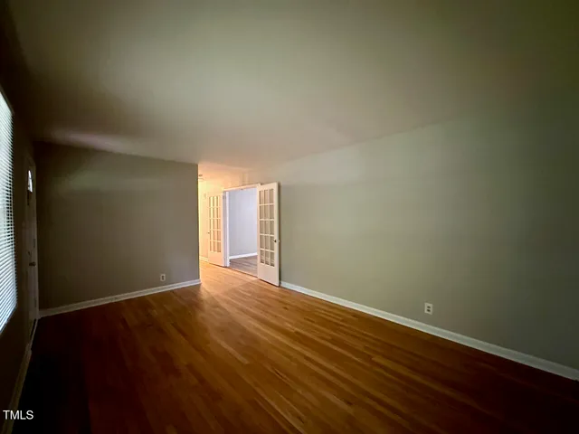 a view of an empty room with wooden floor