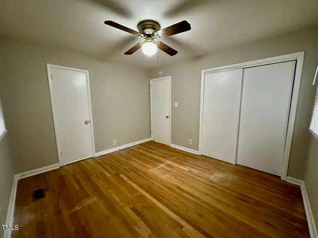 a view of empty room with wooden floor